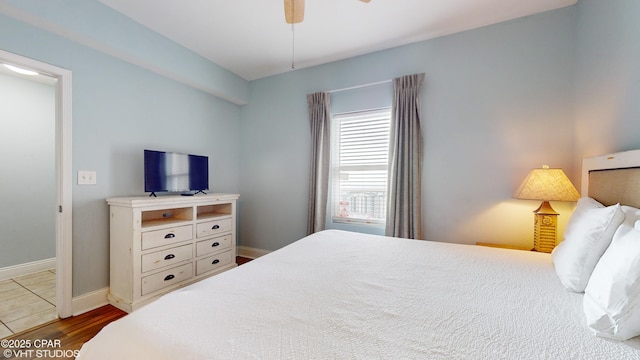 bedroom featuring ceiling fan, wood finished floors, and baseboards