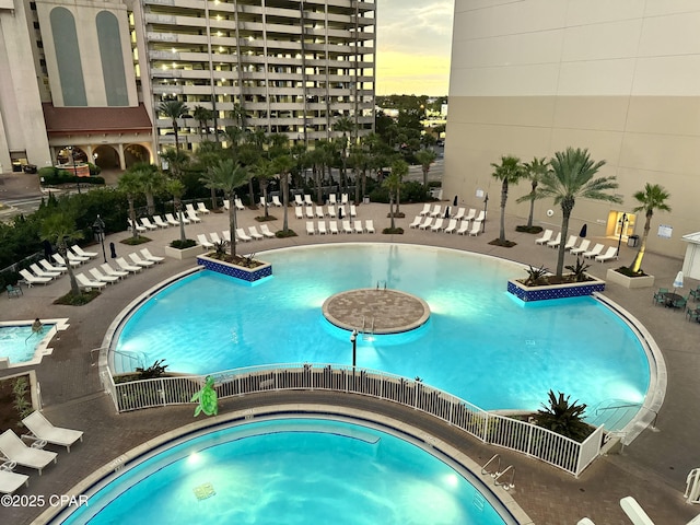 community pool with a patio and a hot tub