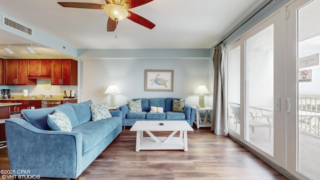 living area featuring light wood-style floors, visible vents, ceiling fan, and track lighting