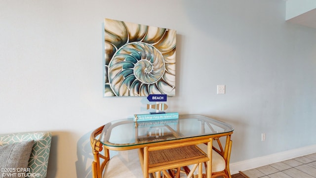 tiled dining area featuring baseboards