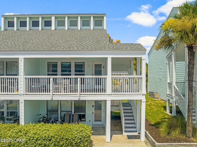 view of front of property featuring a shingled roof and stairs