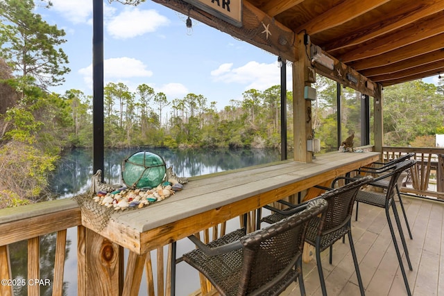 wooden deck featuring outdoor dining space and a water view