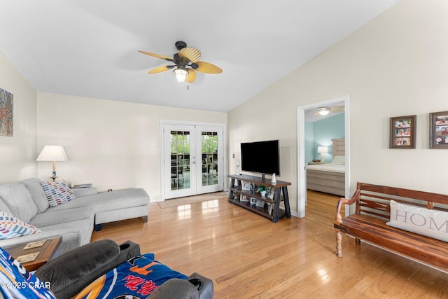 living area featuring lofted ceiling, french doors, light wood-type flooring, and a ceiling fan