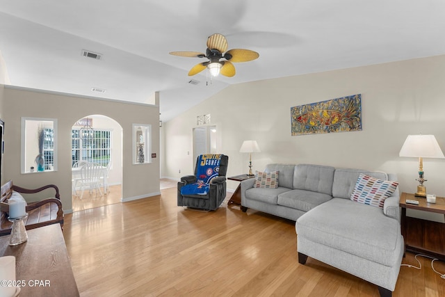 living room with light wood finished floors, ceiling fan, visible vents, and vaulted ceiling