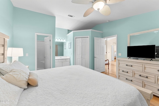 bedroom featuring lofted ceiling, ceiling fan, connected bathroom, light wood-style flooring, and visible vents