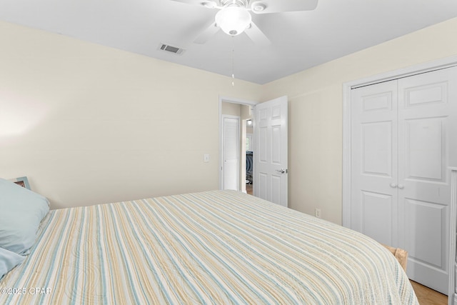 bedroom featuring a ceiling fan, visible vents, a closet, and wood finished floors