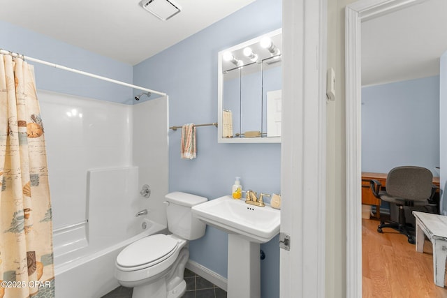 bathroom featuring visible vents, toilet, wood finished floors, shower / bathtub combination with curtain, and a sink