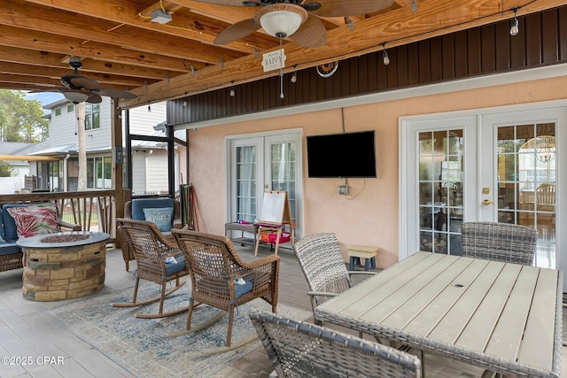 deck featuring french doors, an outdoor fire pit, and a ceiling fan