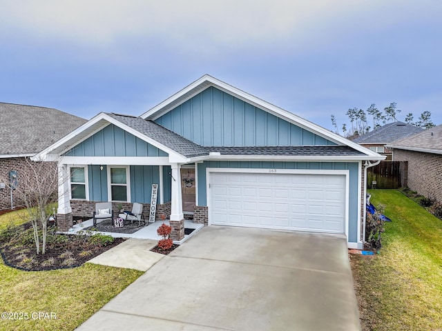 ranch-style home featuring an attached garage, concrete driveway, roof with shingles, board and batten siding, and a front yard