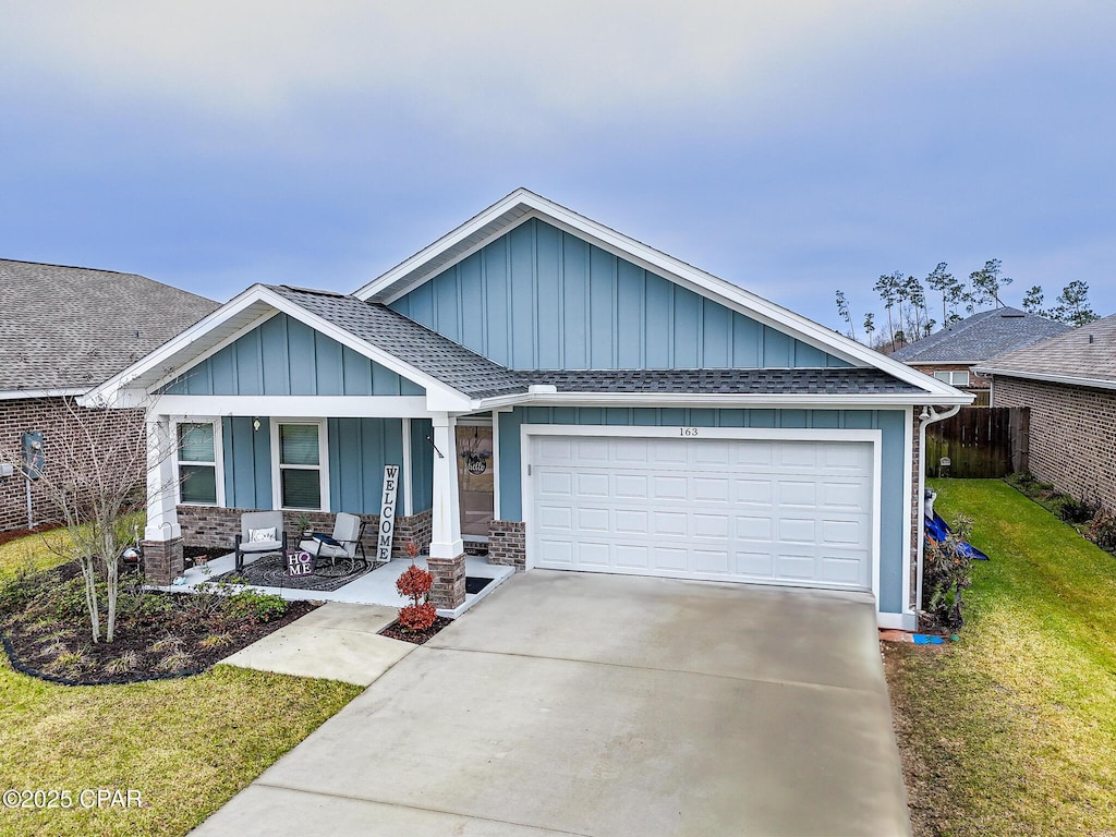 163 Drews Ln, Panama City, FL 32405 - ranch-style house with board and batten siding, fence, a front yard, a garage, and driveway