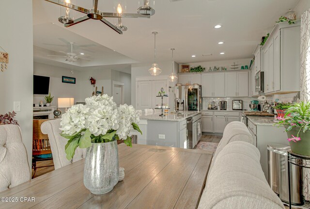 dining area with light wood finished floors, a ceiling fan, and recessed lighting