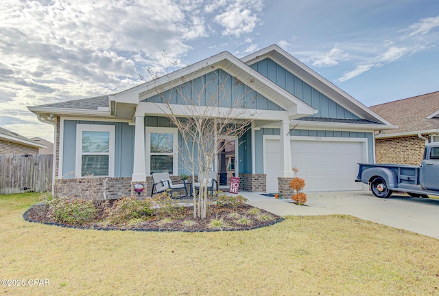 craftsman house with a garage, fence, driveway, board and batten siding, and a front yard