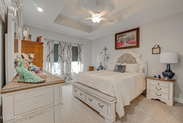 bedroom with recessed lighting, ceiling fan, a raised ceiling, and light colored carpet