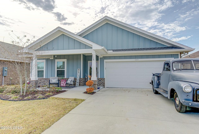 view of front facade with a garage, concrete driveway, covered porch, board and batten siding, and brick siding