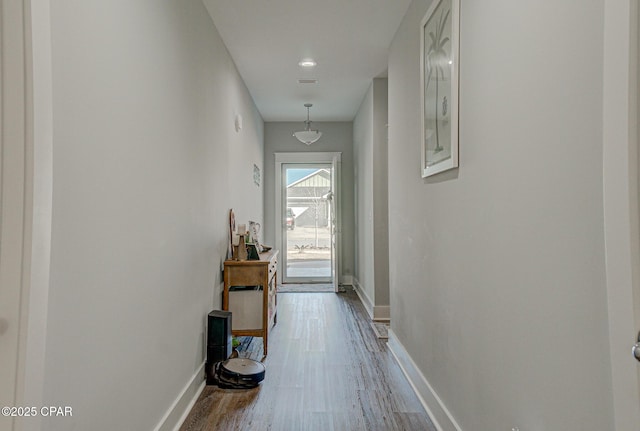 hall featuring baseboards and wood finished floors