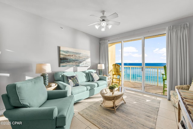 living room with light tile patterned floors, ceiling fan, and a water view