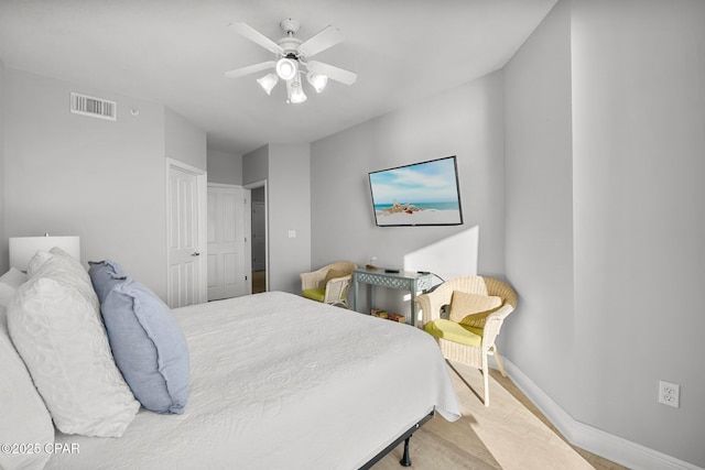 bedroom featuring baseboards, visible vents, wood finished floors, and a ceiling fan