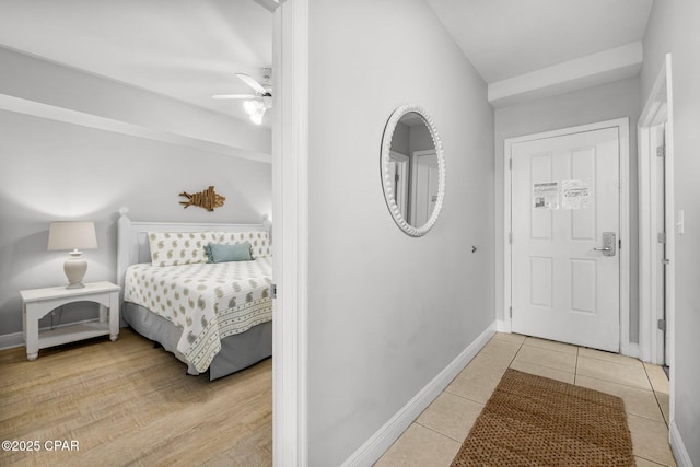 tiled bedroom featuring ceiling fan and baseboards