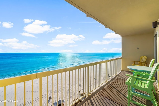 balcony featuring a beach view and a water view