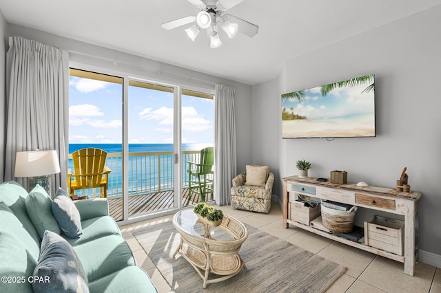 living area featuring baseboards, ceiling fan, and tile patterned flooring