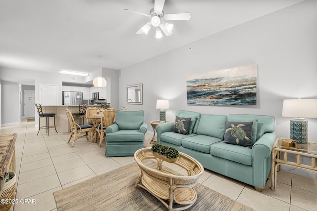 living room featuring baseboards, light tile patterned floors, and ceiling fan