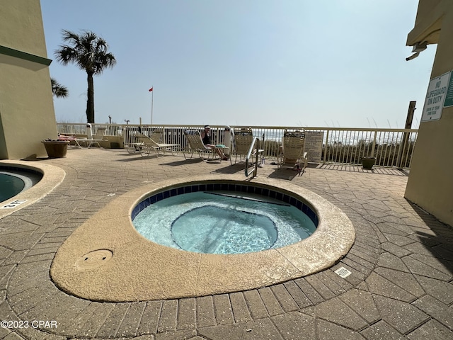 view of pool with a patio and a hot tub