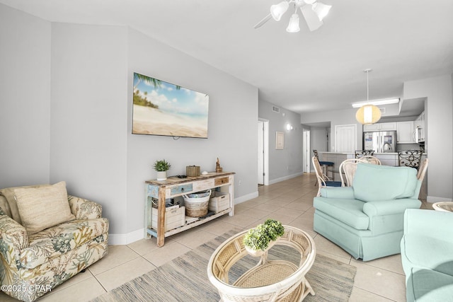living area with baseboards, visible vents, light tile patterned floors, and a ceiling fan