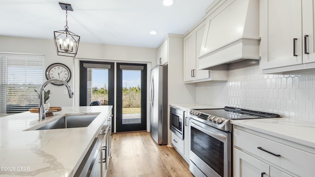 kitchen featuring white cabinets, a sink, custom exhaust hood, stainless steel appliances, and backsplash