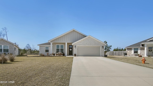 view of front of property featuring driveway, an attached garage, fence, board and batten siding, and brick siding