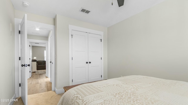 bedroom featuring carpet floors, a ceiling fan, visible vents, and a closet