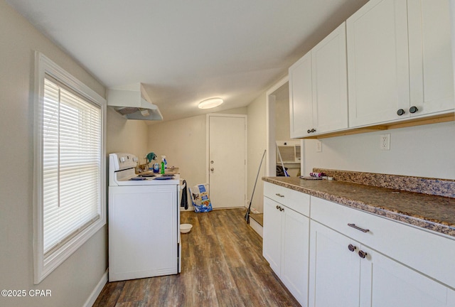 kitchen featuring under cabinet range hood, dark wood-type flooring, white cabinets, dark countertops, and washer / dryer