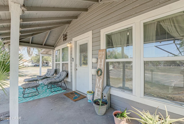 exterior space with vaulted ceiling with beams and wood ceiling