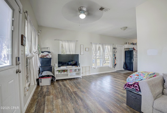 living room featuring baseboards, ceiling fan, visible vents, and wood finished floors