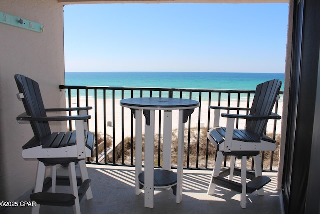 balcony featuring a water view and a view of the beach