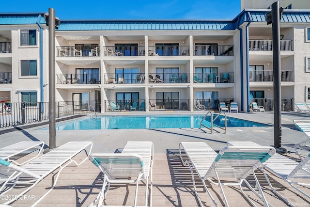 pool with a patio and fence