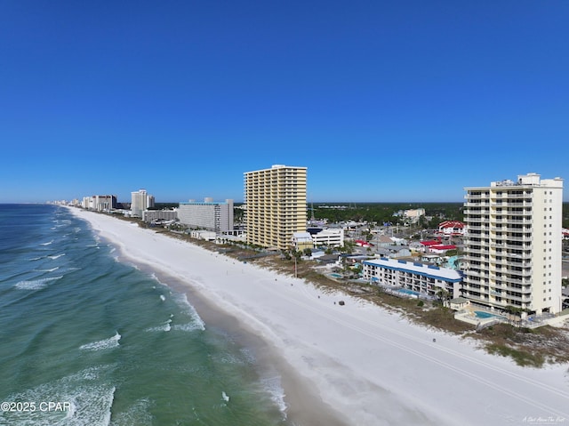 drone / aerial view featuring a city view, a water view, and a beach view