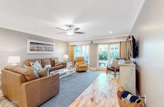 living area with baseboards, crown molding, a ceiling fan, and light wood-style floors