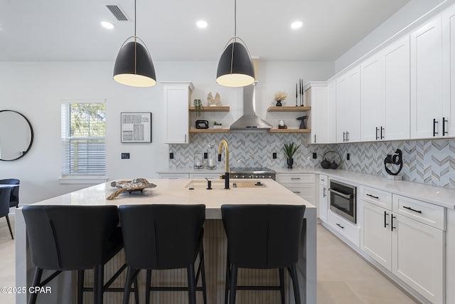 21403 Sunset Ave, Panama City Beach, FL 32413 - kitchen featuring open shelves, decorative backsplash, a sink, a kitchen bar, and white cabinetry