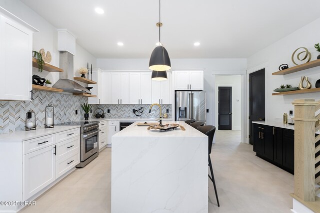 21403 Sunset Ave, Panama City Beach, FL 32413 - kitchen featuring open shelves, appliances with stainless steel finishes, wall chimney exhaust hood, an island with sink, and recessed lighting