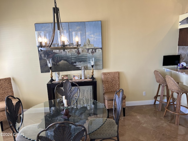 dining area with a chandelier and baseboards