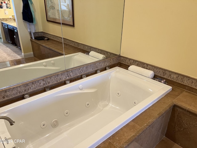 full bath with vanity and a tub with jets