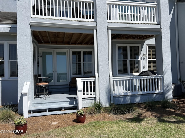 property entrance with central air condition unit, french doors, and stucco siding