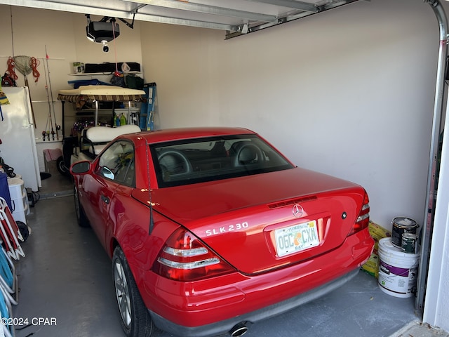 garage featuring a garage door opener and freestanding refrigerator