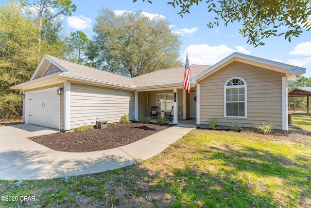 single story home with a garage, covered porch, driveway, and a front lawn