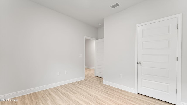 unfurnished bedroom with visible vents, light wood finished floors, and baseboards