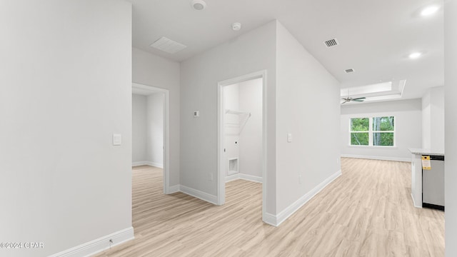 hall with light wood-type flooring, visible vents, and baseboards