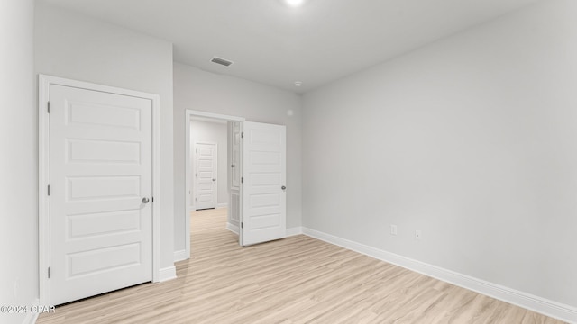 unfurnished bedroom with light wood-style floors, visible vents, and baseboards