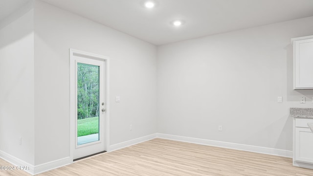 unfurnished dining area with light wood finished floors, recessed lighting, and baseboards