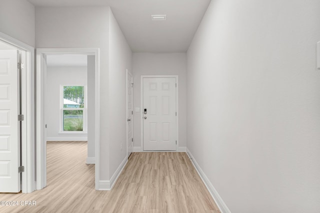 hall with light wood finished floors and baseboards