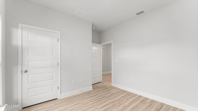 unfurnished bedroom with light wood-type flooring, visible vents, and baseboards